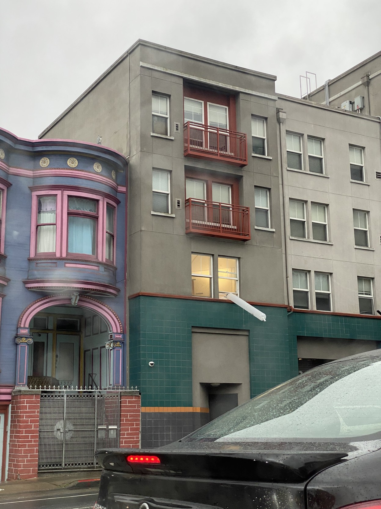 what looks like about a 12 foot clear plastic cylinder about a foot in diameter blowing solid out a propped up window on the first floor over a soft story garage on ceasar chavez street in san francisco, pointing down about 30 degrees