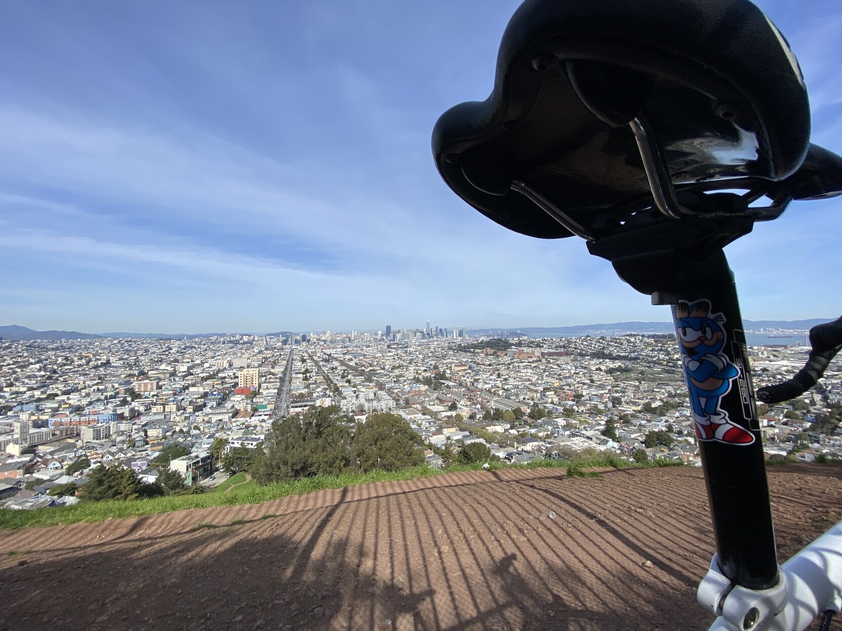 downtown san francisco as seen from the radio antenna fence line atop Bernal Heights, framed on the right side by the seat post of my bike