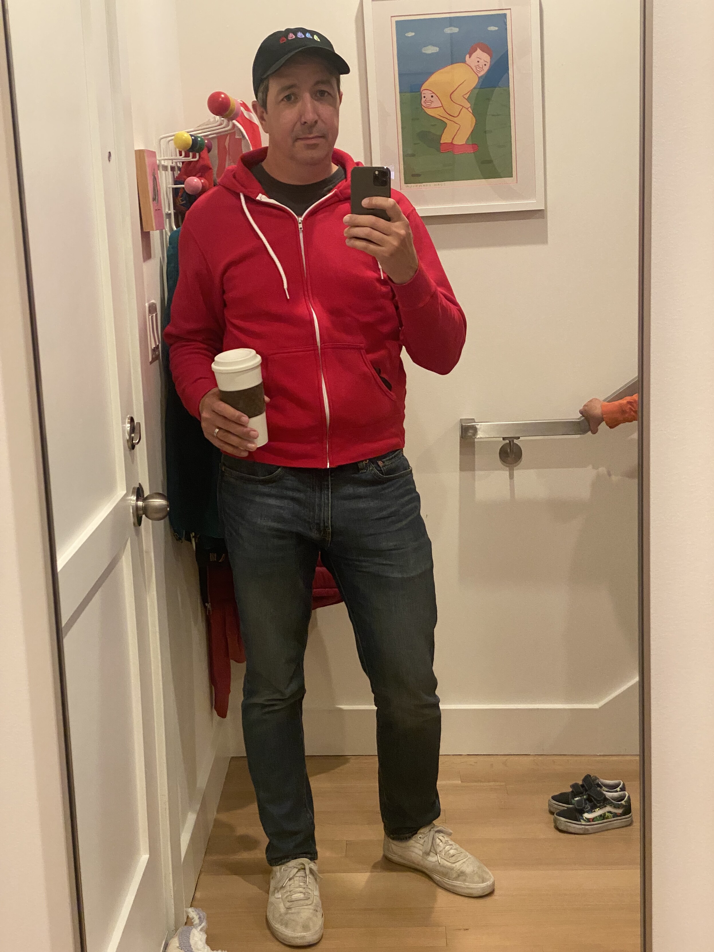 full length mirror selfie, white vans, blue jeans, red zip hoodie, black t-shirt, black bell cap, white to-go coffee