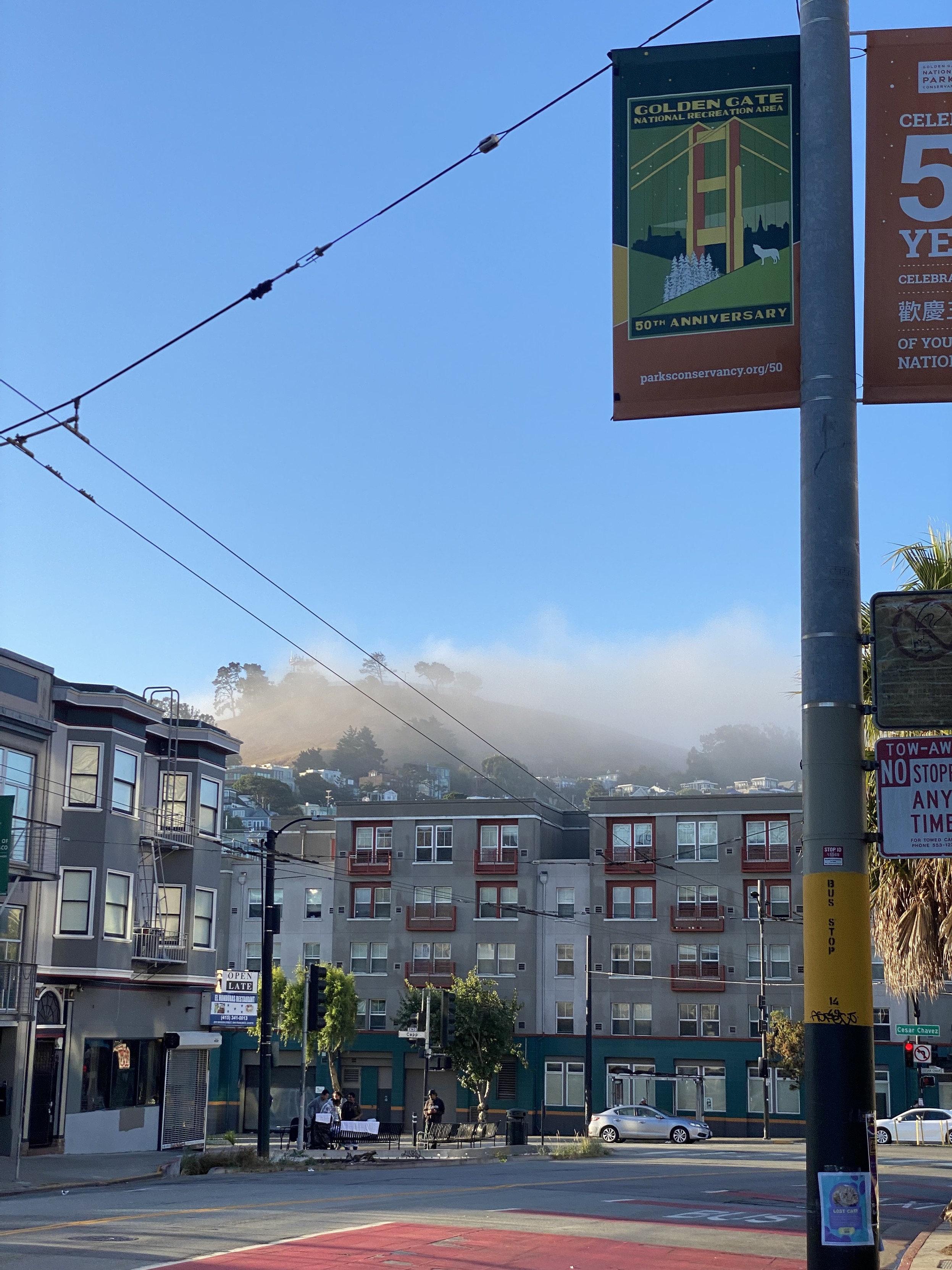 bernal heights from the west side of mission street between 26th and caesar chavez, 7:40AM, clear blue skies, but the heights are shrouded in fog from the west