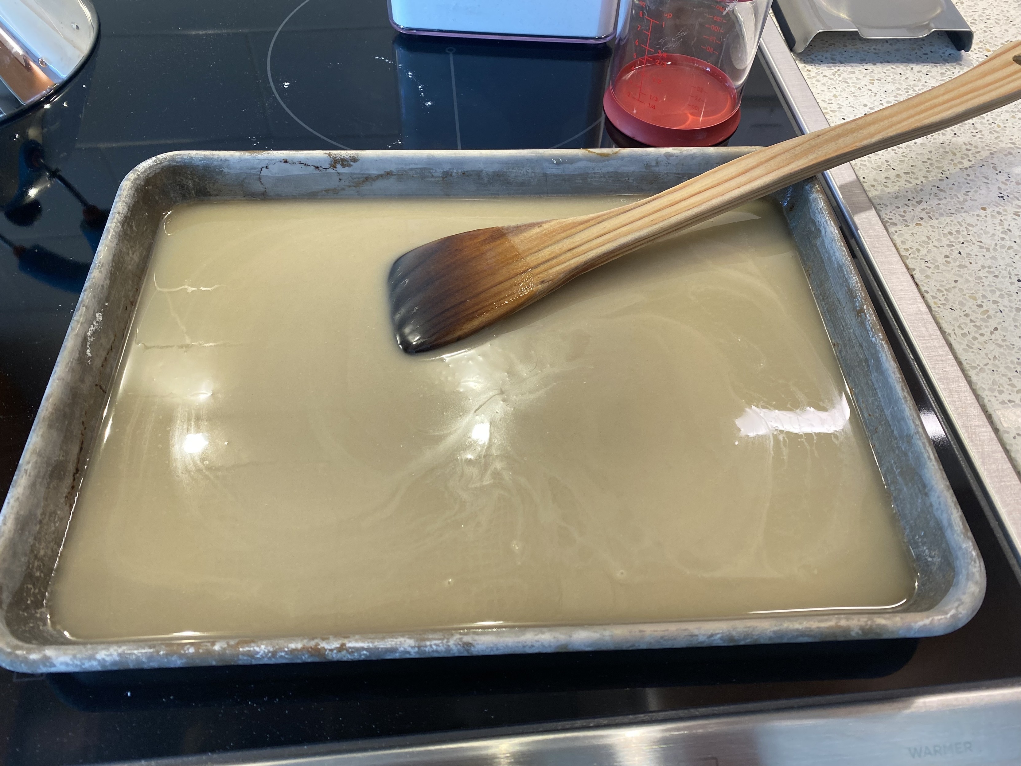 the raw roux, mixed, pale, in a quarter sheet, about to go into the oven, which i had just stirred with my roux spoon