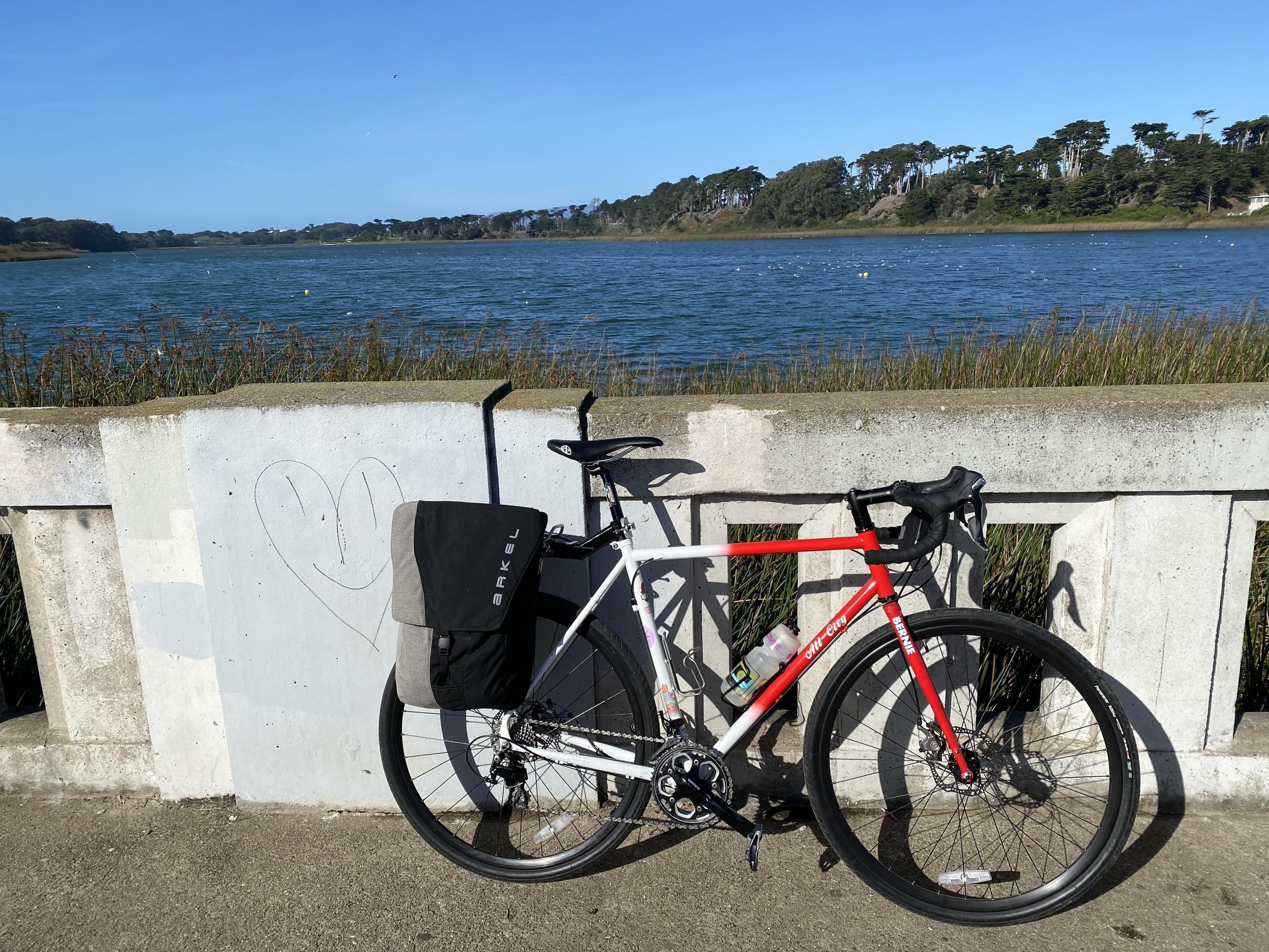 my red and white all city macho man on a pedestrian bridge over lake merced, looking north