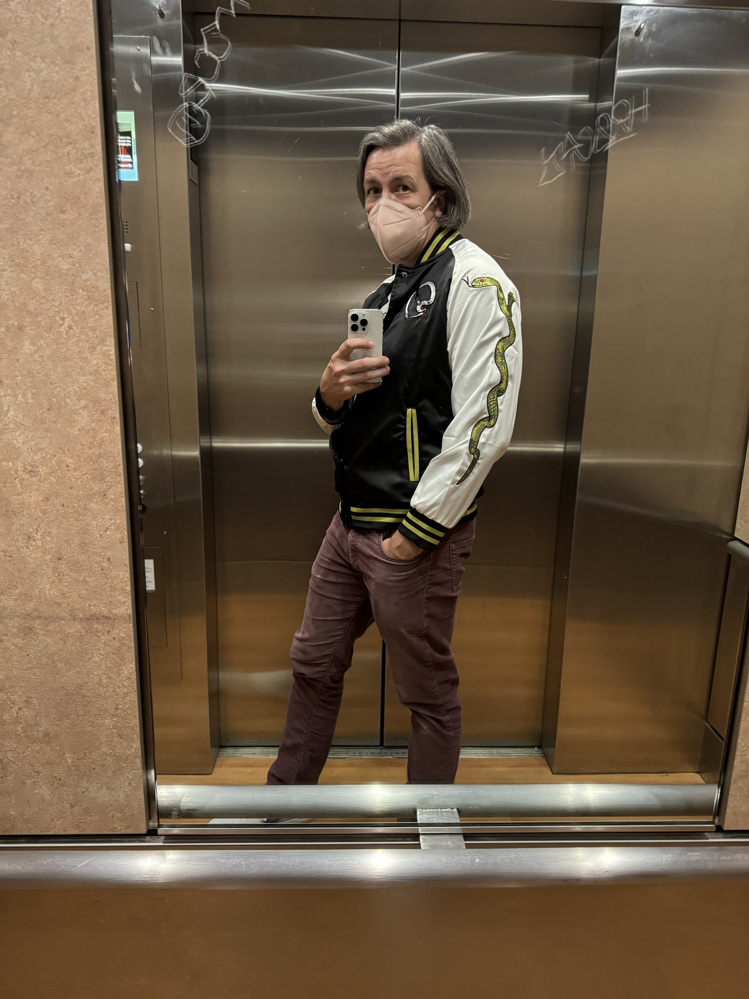 selfie in an elevator mirror wearing a new rock band jacket, black with white sleeves, green striped cuffs, collar, waist, and pockets, with a green two headed snake running up the sleeveI was on the way to see a doctor about a thing that cleared up the day before and two hours after I confirmed the $75-cancellation-fee appointment that I'd made three weeks prior