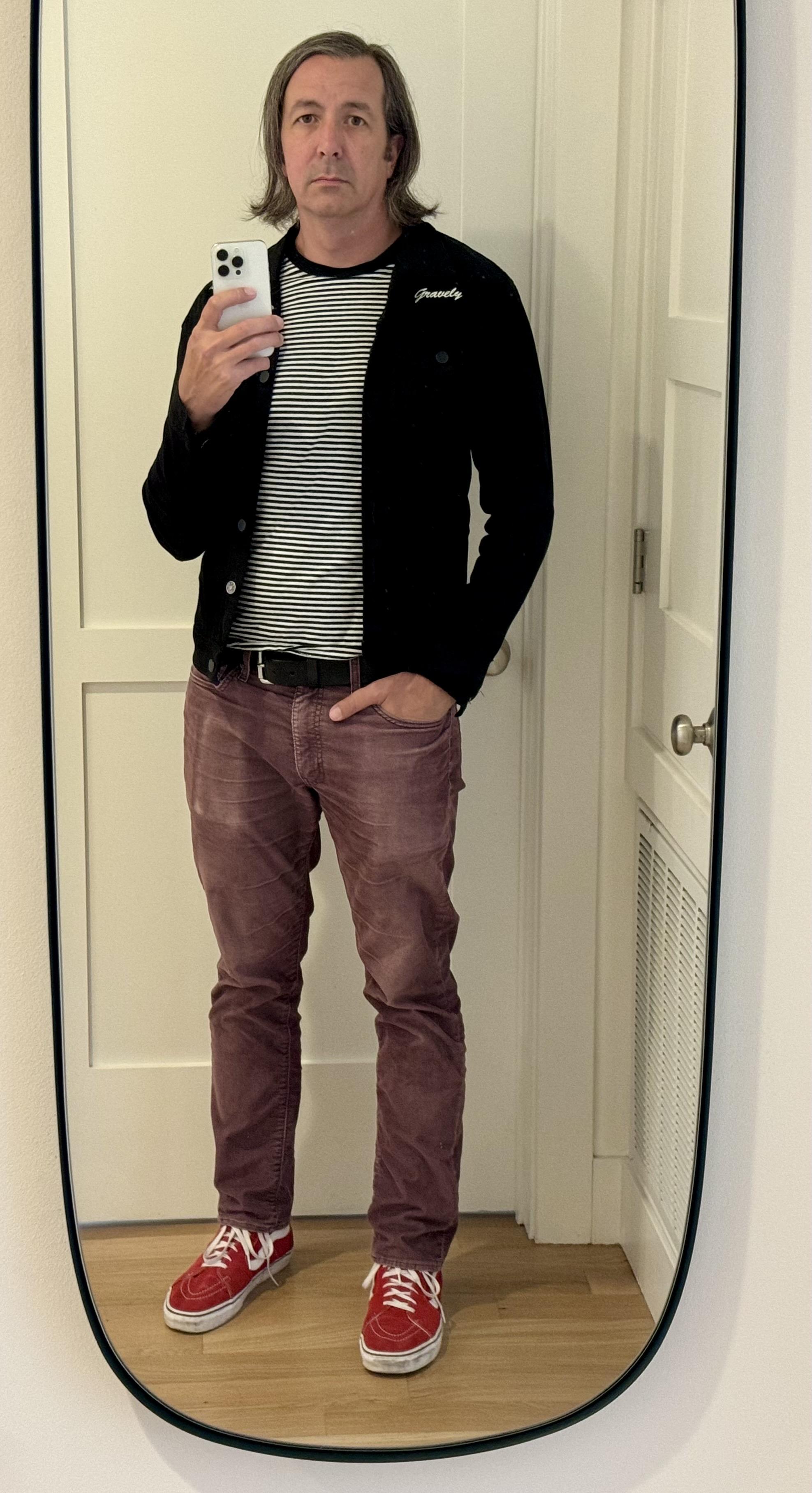 full length mirror selfie, red/white-stripe high top vans, maroon levis corduroys, black/white thin-hoirzontal-striped shirt under a black jean jacket with ‘gravely’ embroidered in cursive above the the left pocket, nearly-shoulder length hair parted on my left, flipping up at the ends in a mess because I haven’t touched it in a long time