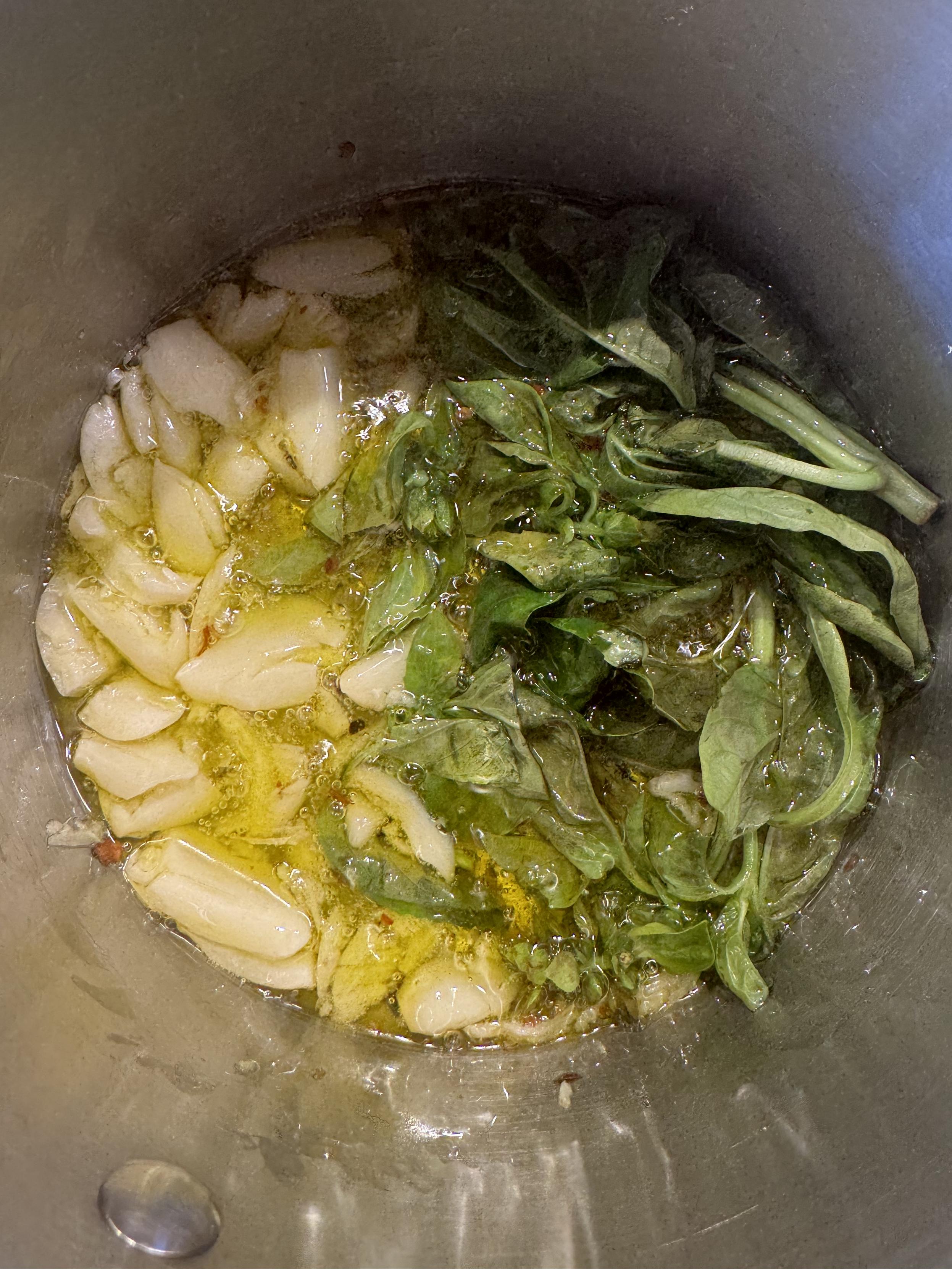 garlic cloves from an entire head, enough basil, stem and all, to fill the rest of a small sauce pan, and a healthy pinch of red pepper flakes, frying in a quarter cup of olive oil