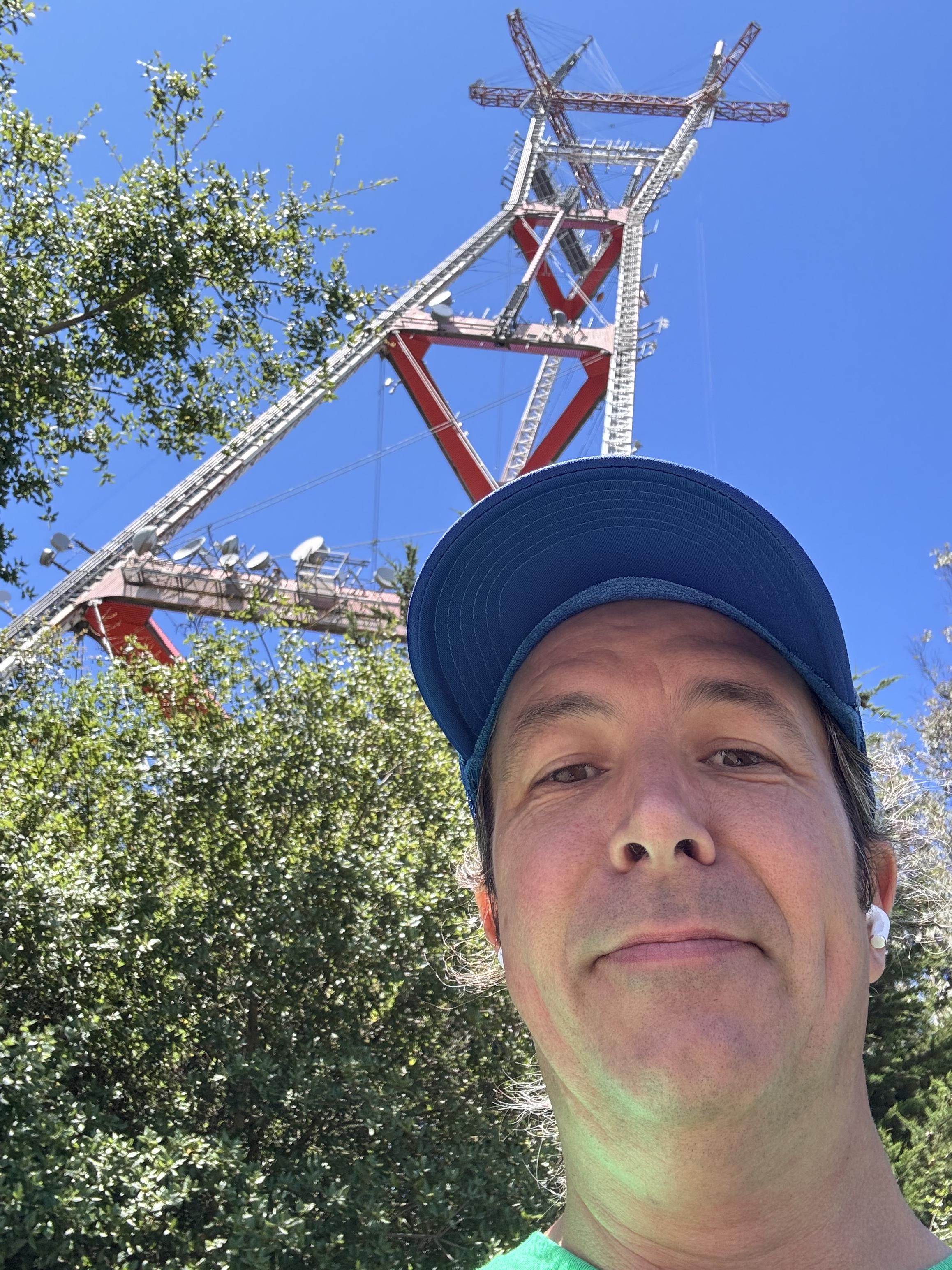 selfie more or less under the tower of a large radio tower in san francisco, or at least as close as it can be approached without working there