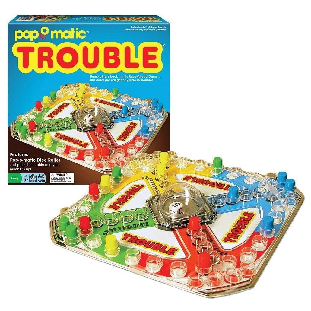 sales photo of the board game TROUBLE, which I played the heck out of when I like six years old, over a white void in the matrix or whatever. The box faces us in single point perspective in the top left and the game itself in red, green, yellow, and blue at a jaunty angle as if on a table in front of usthe entire premise of the game is that you can push on a clear plastic bubble in the middle to make a die role insidepop ° matic®Instrucciones del juego ingles y espasolTROUBLEBump others back in this Race-Ahead Game...But don't get caught or you're in Trouble!TROUBLETROVOURFeaturesPop-o-matic Dice RollerJust press the bubble and yournumber's up!Famity5+|25-35 | PLAYERSA WARNING:CHOKING HAZARO ThiS tY3800TROUGLE