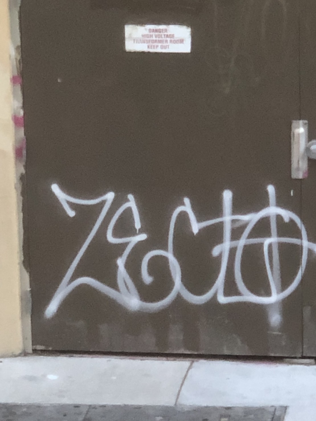 white spray tag on a green door by ZECLO