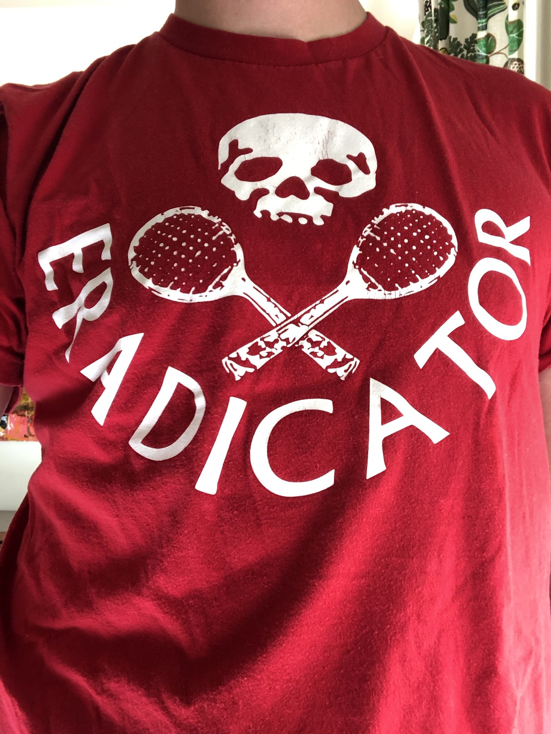 red t-shirt with a white skull, crossed squash rackets, and the word ERADICATOR on it